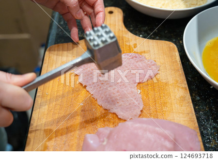 Tenderize meat, beating, hammering fillet pieces, cooking schnitzel process closeup Tenderize meat, beating, hammering fillet pieces, cooking schnitzel process closeup 124693718