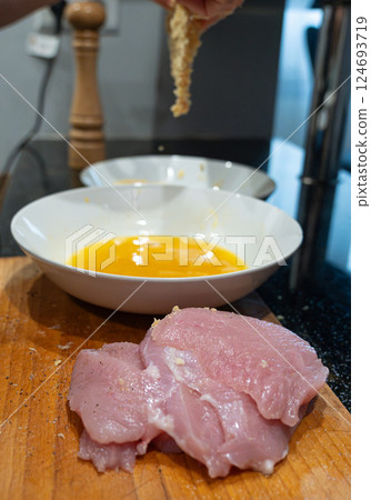 Raw turkey fillet slicing for nuggets or escalope, cut meat with kitchen knife, homemade schnitzel Raw turkey fillet slicing for nuggets or escalope, cut meat with kitchen knife, homemade schnitzel 124693719