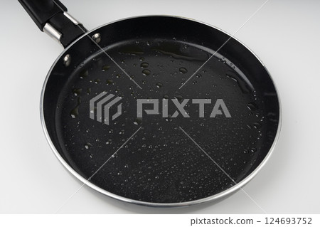 Oil drops on frying pan texture, water splash on black non-stick coating, drop on non stick griddle 124693752