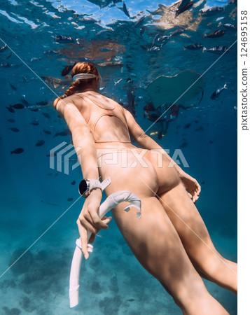 Woman with sexy body close up in sea with tropical fish, swimming underwater Woman with sexy body close up in sea with tropical fish, swimming underwater 124695158