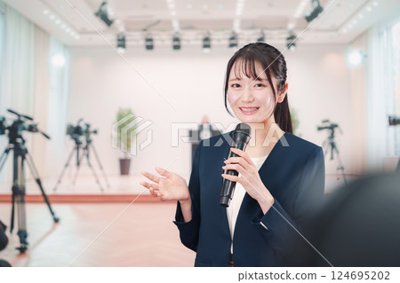 A female announcer reporting from a press conference 124695202