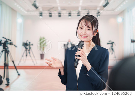 A female announcer reporting from a press conference 124695203