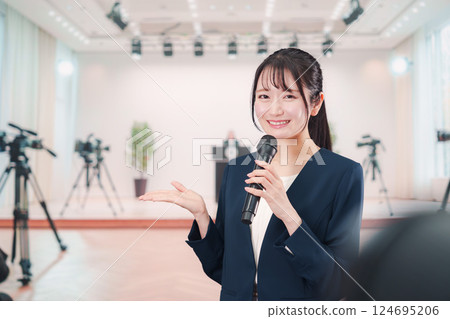 A female announcer reporting from a press conference A female announcer reporting from a press conference 124695206
