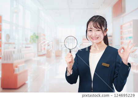 Smiling beauty consultant woman holding a magnifying glass Smiling beauty consultant woman holding a magnifying glass 124695229