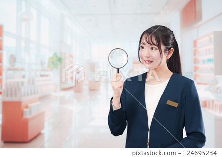Smiling beauty consultant woman holding a magnifying glass 124695234
