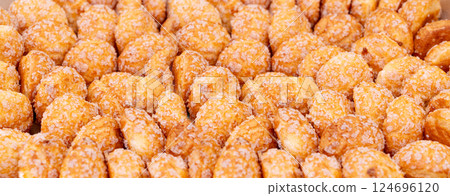 Puff pastries texture background, round sugar-coated sugar puffs pattern, golden crispy baked 124696120