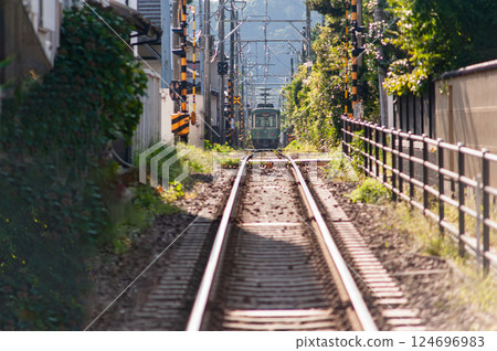 Enoden train running between houses, Kamakura, Kanagawa Prefecture 124696983