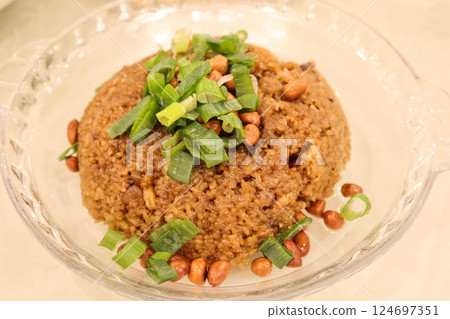 Close up of stir fried Chinese sausage sticky rice (glutinous rice) with peanuts and spring onion on a glass plate 124697351