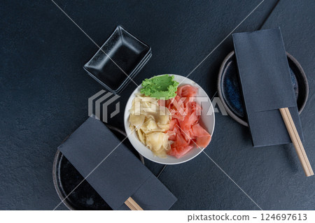 Pickled ginger and wasabi bowl on dark table, traditional Japanese condiments served with sushi 124697613