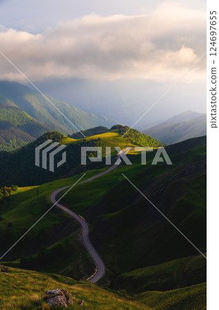 Panoramic view of green mountains and hills at sunset. Pass. Beautiful summer landscape Panoramic view of green mountains and hills at sunset. Pass. Beautiful summer landscape 124697655