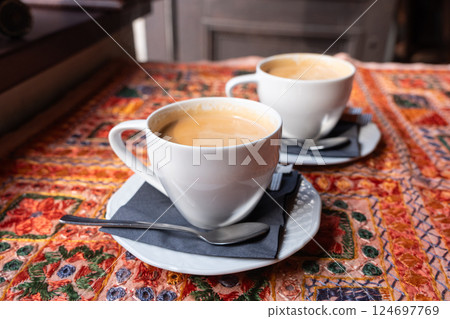 Masala chai an Indian restaurant, spiced milk tea, traditional cardamom hot drink with spices 124697769