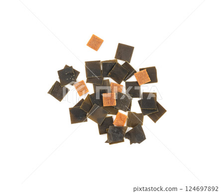 Dry kelp seaweed squares, mini wakame pieces isolated, dried kombu and carrot flakes from ramen Dry kelp seaweed squares, mini wakame pieces isolated, dried kombu and carrot flakes from ramen 124697892