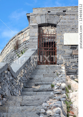 Stone steps between medieval walls of houses in bay of Porto Venere, Liguria. Tourism in Italy. Traditional buildings. Background for design. Stone steps between medieval walls of houses in bay of Porto Venere, Liguria. Tourism in Italy. Traditional buildings. Background for design. 124698312