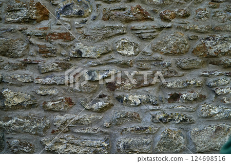 Old stone wall patterned texture or background. Gey stone texture background, close-up panoramic image Old stone wall patterned texture or background. Gey stone texture background, close-up panoramic image 124698516