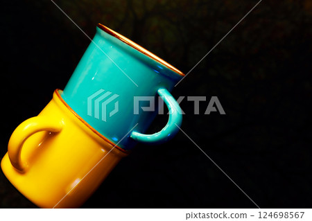 Coffee break,tea time.Yellow blue cups on dark surface Coffee break,tea time.Yellow blue cups on dark surface 124698567