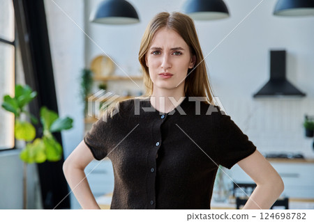 Portrait of serious angry upset female teenager looking at camera with in home interior Portrait of serious angry upset female teenager looking at camera with in home interior 124698782