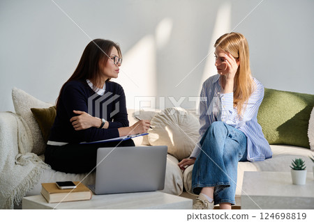Sad upset young female patient in therapy session in psychologist office 124698819