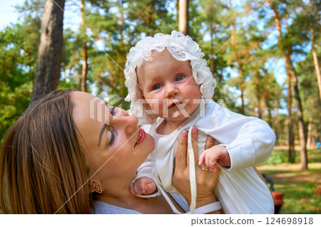 Young happy mother with a cute breast newborn baby in a sunny forest 124698918