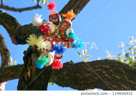 Festive bunch of colorful painted Easter eggs on green spring tree 124698932