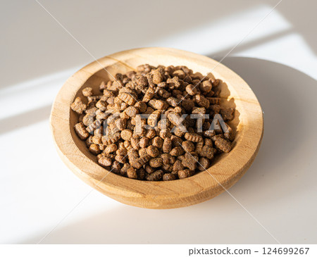 Dry pet food in sunlight, dog kibble pile, scattered puppy pellets, small canine protein croquette Dry pet food in sunlight, dog kibble pile, scattered puppy pellets, small canine protein croquette 124699267