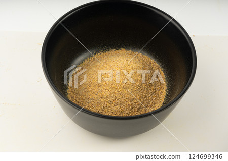 Ground fenugreek seeds in black bowl, milled dry trigonella powder, spicy methi dana pounded Ground fenugreek seeds in black bowl, milled dry trigonella powder, spicy methi dana pounded 124699346