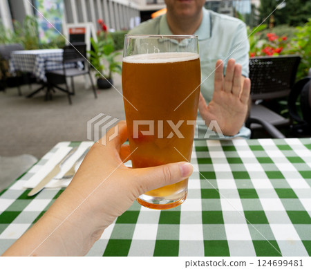 Reject a glass of beer, man refusing alcohol, stop drinking, sobriety concept, saying no to beer glass 124699481