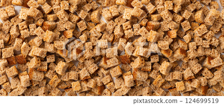 Homemade rye bread croutons texture background top view. Crispy bread cubes pattern Homemade rye bread croutons texture background top view. Crispy bread cubes pattern 124699519