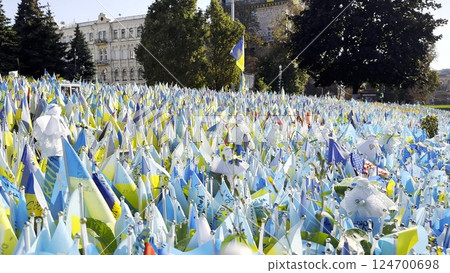 Many small blue-yellow flags with names of the dead war against russia. Memorial of the fallen soldiers, children, women in the capital of Ukraine. Concept of tragedy and misfortune. Close up Many small blue-yellow flags with names of the dead war against russia. Memorial of the fallen soldiers, children, women in the capital of Ukraine. Concept of tragedy and misfortune. Close up 124700698