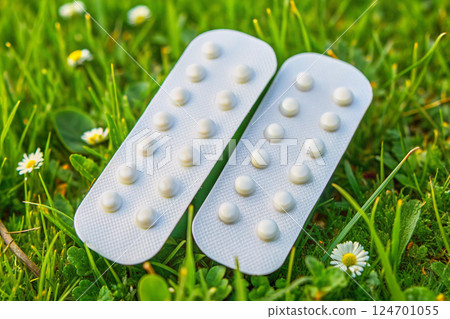 Healing.White pills in blister on green grass meadow Healing.White pills in blister on green grass meadow 124701055