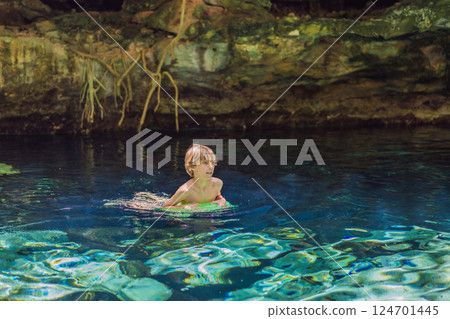 Young boy exploring a stunning Mexican cenote with turquoise water. Adventure, travel, and nature discovery concept Young boy exploring a stunning Mexican cenote with turquoise water. Adventure, travel, and nature discovery concept 124701445