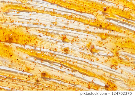 Honey and mustard sauce spread with mustard seeds on white surface in close up 124702370