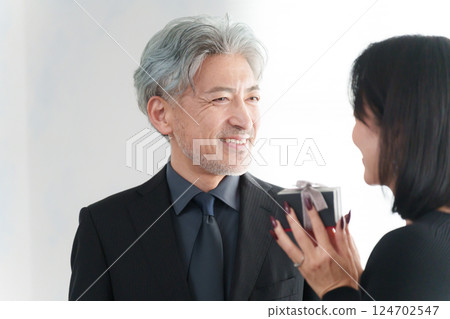 A woman receiving a gift from a man (couple) A woman receiving a gift from a man (couple) 124702547