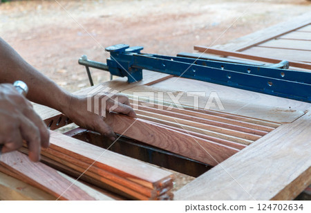 Carpenter working with equipment on wooden table, working with wooden door in new home interior industry. 124702634