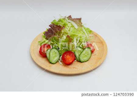 Raw vegetable salad and white background Tomato, cucumber and lettuce salad 124703390