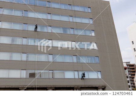 Cleaning worker cleaning the windows of a building Stock photo of working at height 124703461