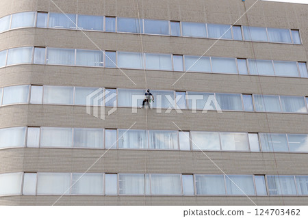 Cleaning worker cleaning the windows of a building Stock photo of working at height 124703462