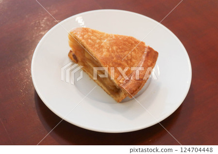 Close up of a slice of baked apple pie on a whit plate with copy space 124704448