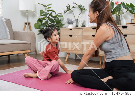 Mother-Daughter Meditation Moment. A mother and her daughter sharing a calm meditation session on a yoga mat. 124704893