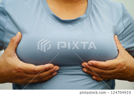 Asian woman self touching check lump or Breast cancer, Breast Self Exam. 124704919