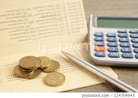 Coins money with calculator and pen on bookbank finance. 124704943