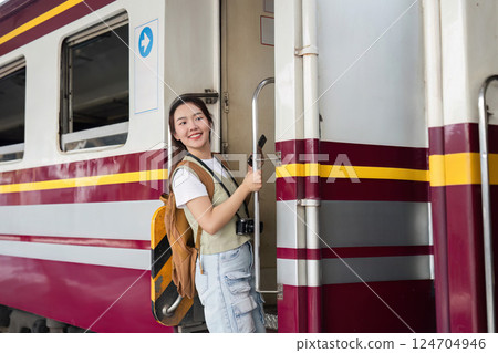 Travel Journey and Boarding Experience. A woman joyfully preparing to board a train, full of enthusiasm for her trip. Travel Journey and Boarding Experience. A woman joyfully preparing to board a train, full of enthusiasm for her trip. 124704946