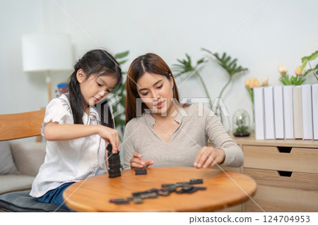 Educational Play and Nurturing Care. A mother guides her child during an engaging game that promotes learning and fun. Educational Play and Nurturing Care. A mother guides her child during an engaging game that promotes learning and fun. 124704953