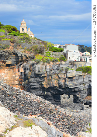 Stone medieval church, fortress walls on rock of Porto Venere, Liguria. Nature, tourism in Italy. Construction and architecture. Background for design.  124706362