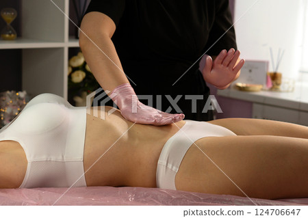 Finishing abdominal massage stroke performed with soft gloved hand. 124706647