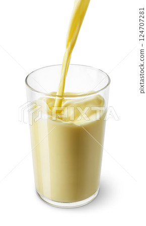banana or vanilla milk pouring into glass isolated on white background banana or vanilla milk pouring into glass isolated on white background 124707281