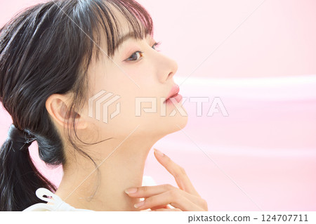 A refreshing beauty image of a young woman photographed against a pink background A refreshing beauty image of a young woman photographed against a pink background 124707711