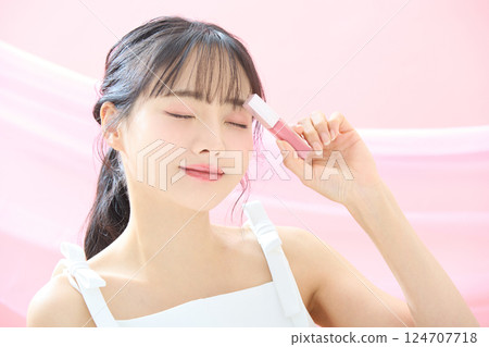 A refreshing beauty image of a young woman photographed against a pink background A refreshing beauty image of a young woman photographed against a pink background 124707718