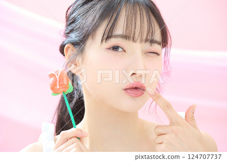 A refreshing beauty image of a young woman photographed against a pink background 124707737