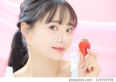 A refreshing beauty image of a young woman photographed against a pink background 124707749
