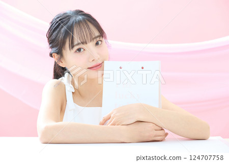 A refreshing beauty image of a young woman photographed against a pink background 124707758